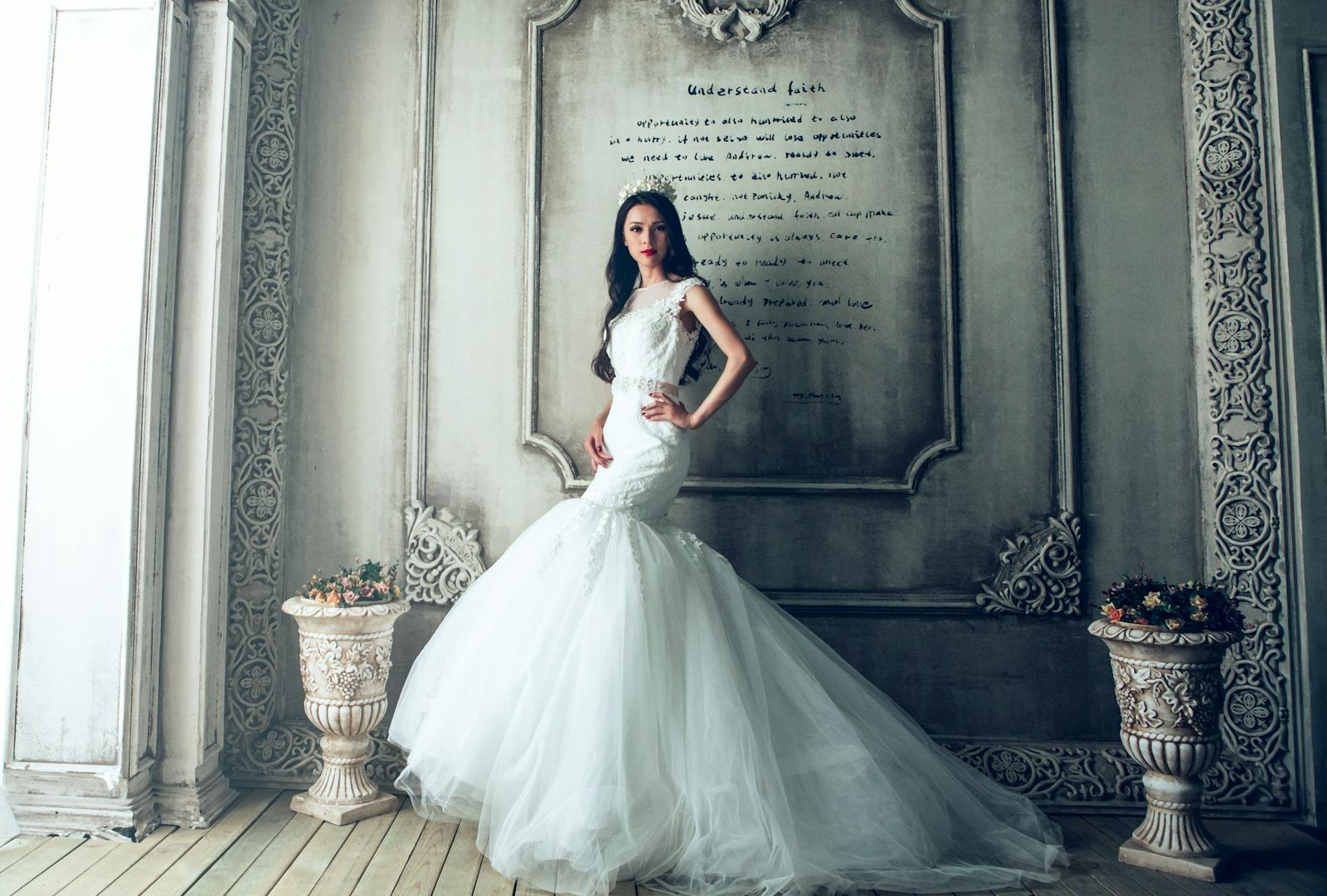 Stunning bride in elegant wedding dress posing in ornate, vintage interior.