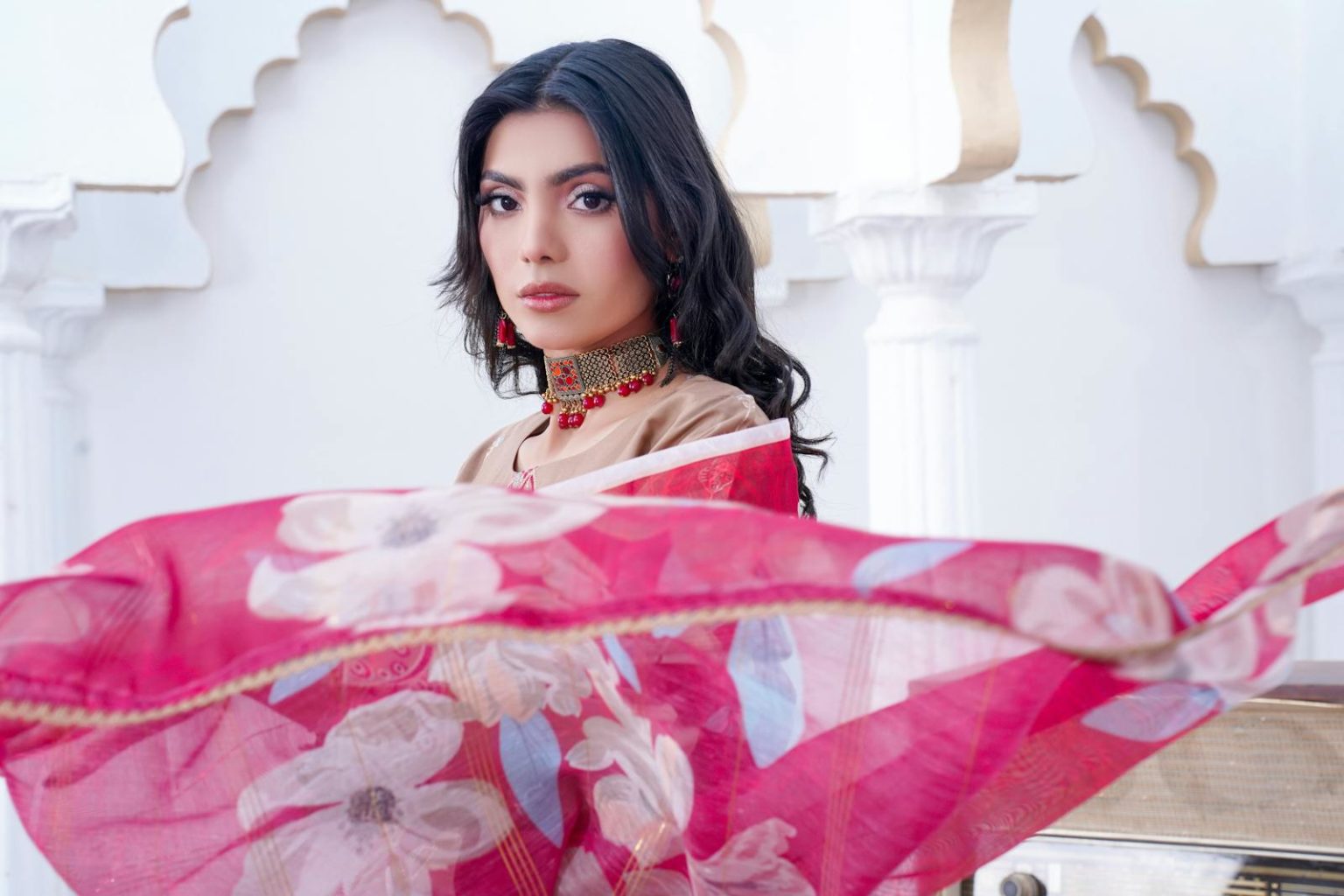 Striking portrait of a fashion model in traditional South Asian attire with vibrant colors.