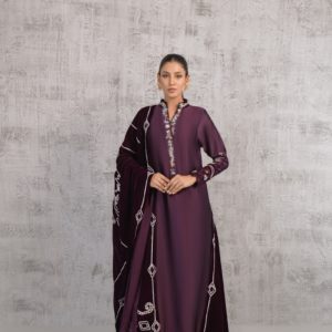 A woman in a purple dress standing in front of a wall