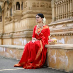 woman in red long sleeve dress sitting on gray concrete bench during daytime