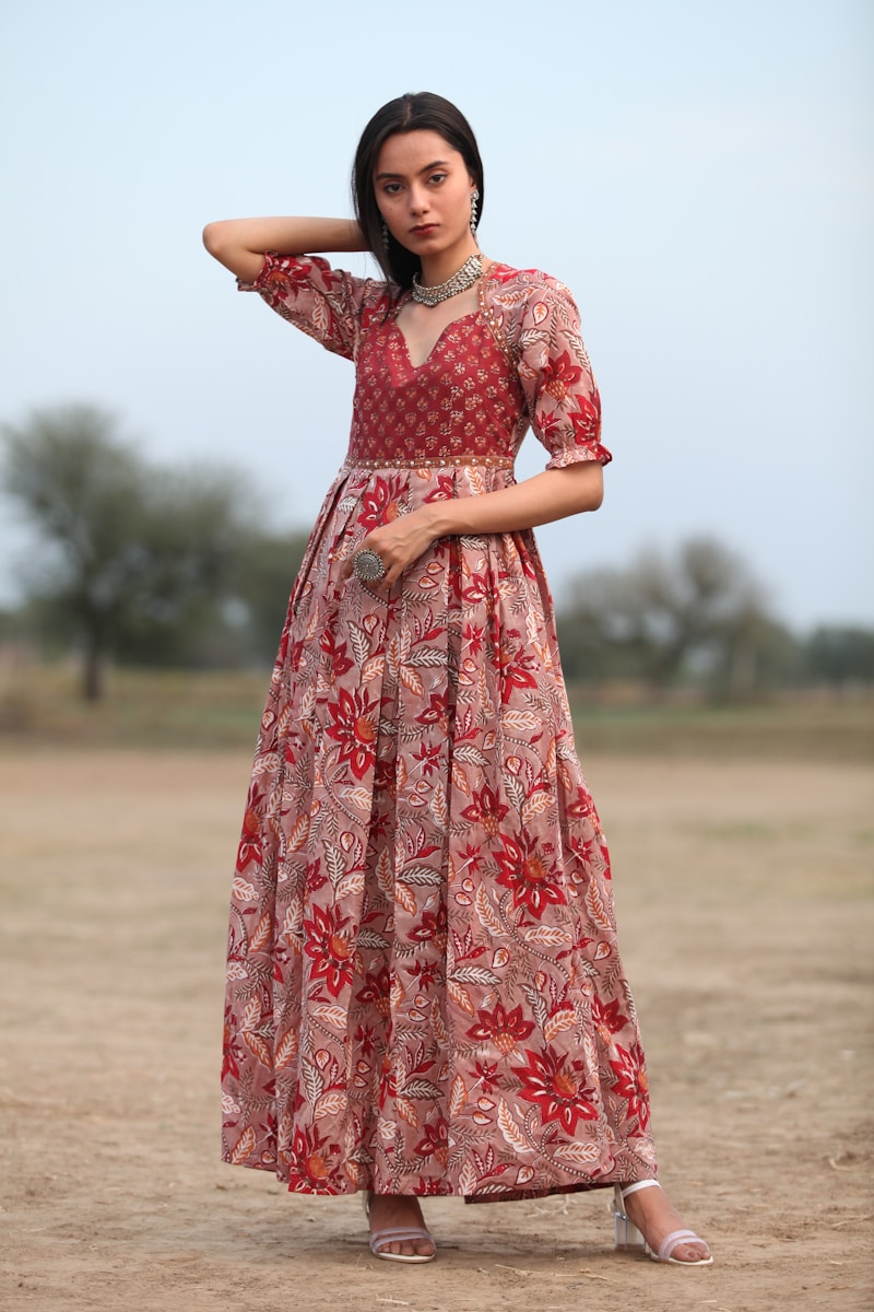 a woman in a long dress standing in a field