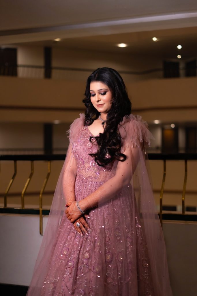 A woman in a pink dress standing in a room